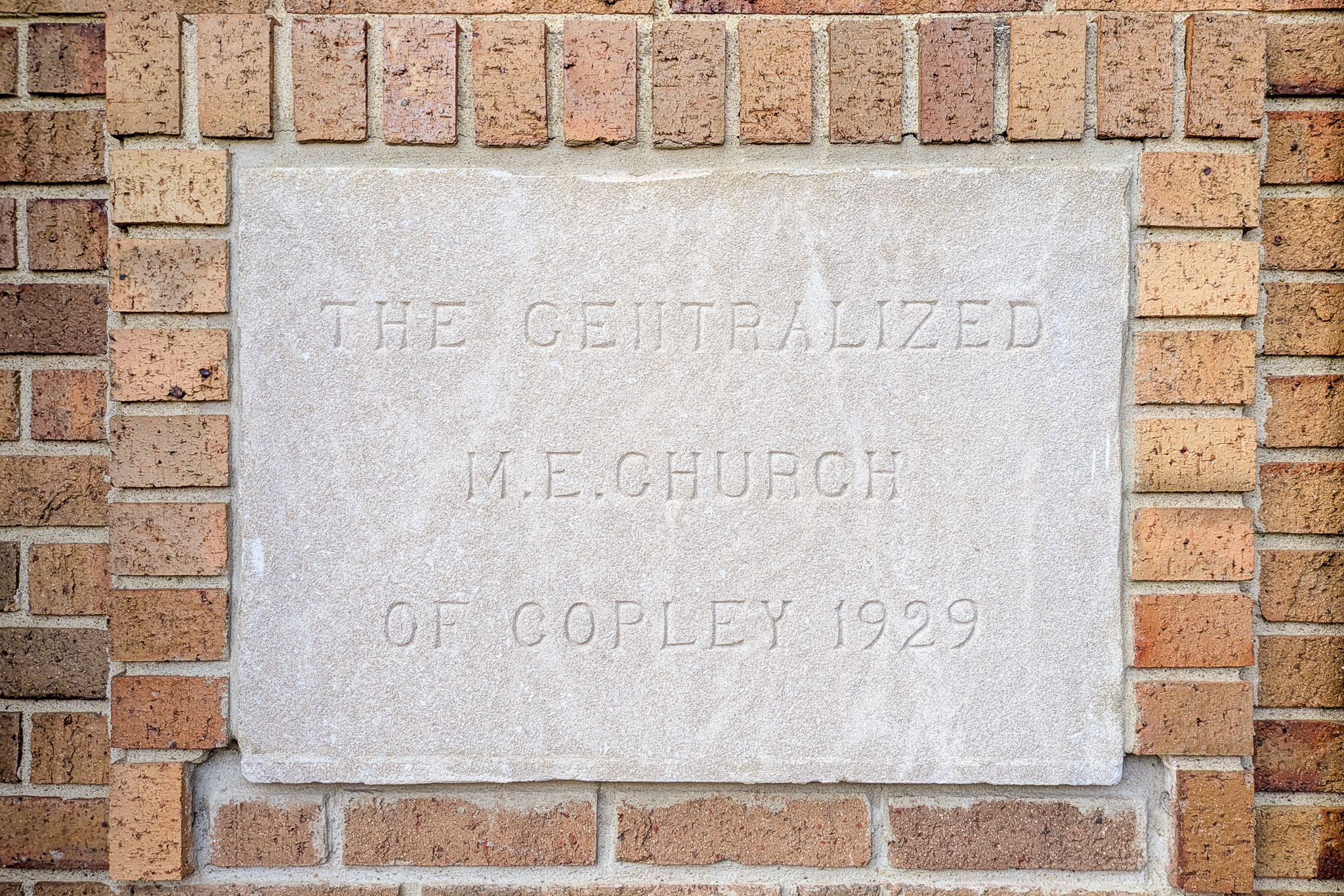 A stone built into the brick building reading “The Centralized M.E. Church of Copley 1929”.