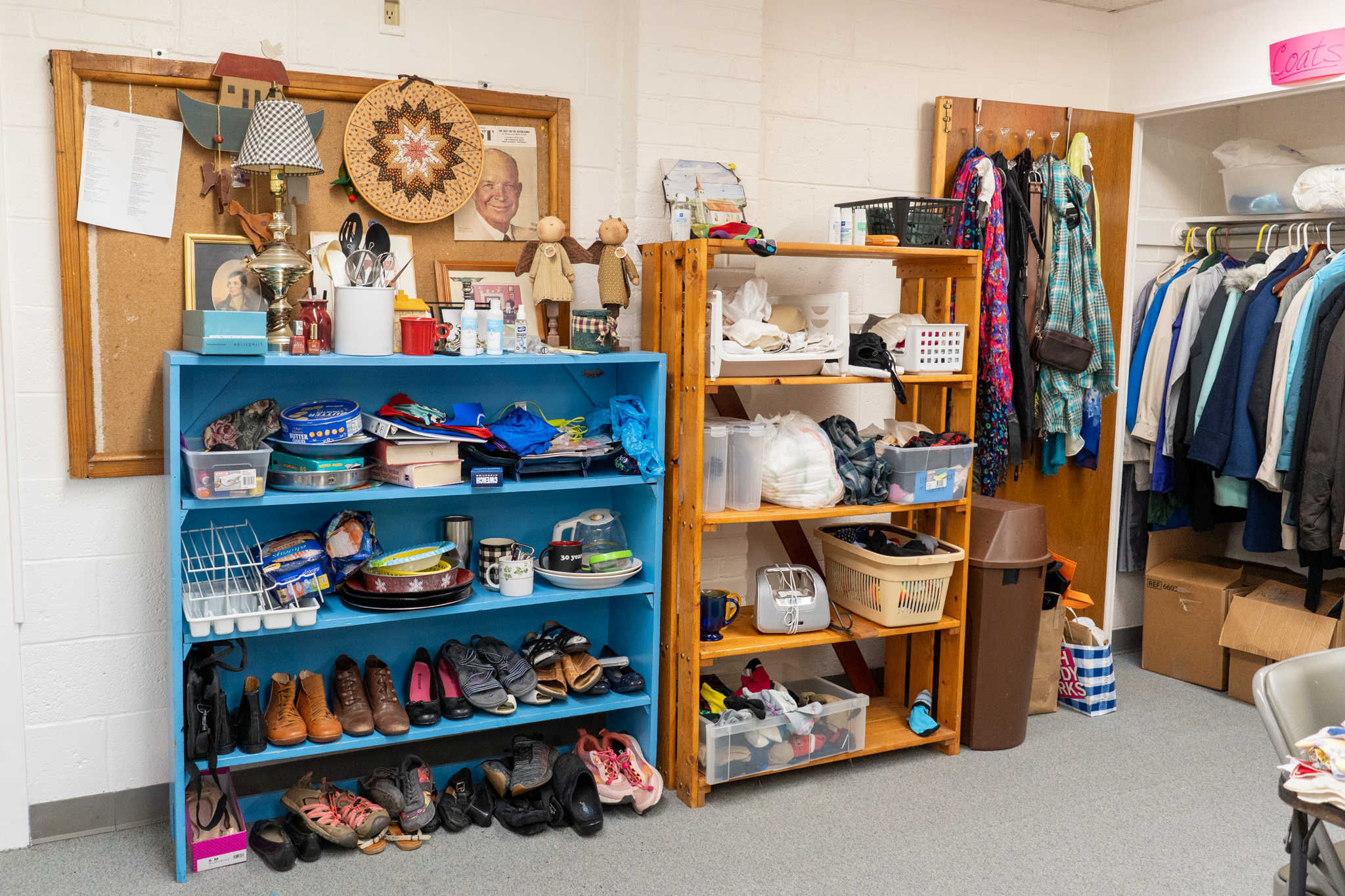 Multiple sets of shoes with household items and shoes, and a closet with coats along with scarfs on the door.