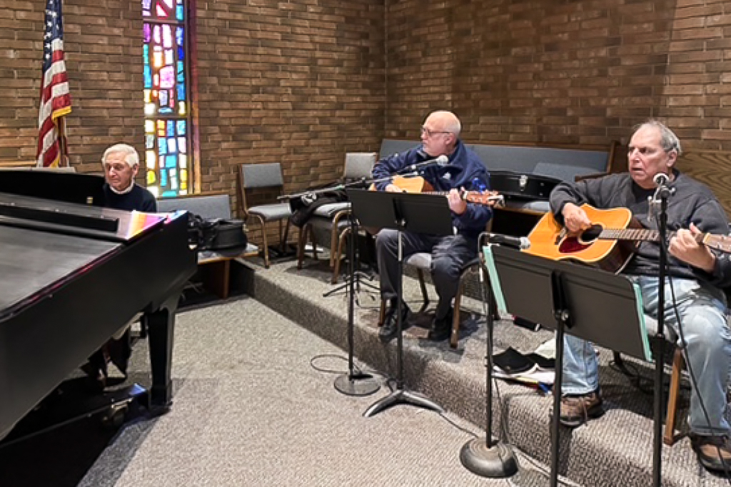 Two guitarist and a pianist practicing on the stage.