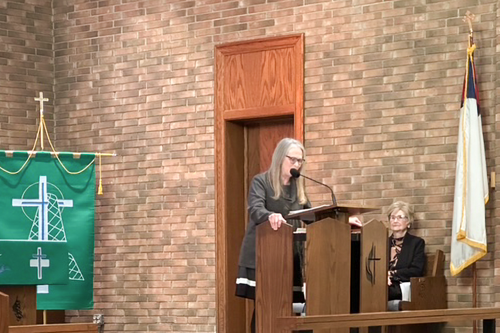 The pastor speaking at the lectern.