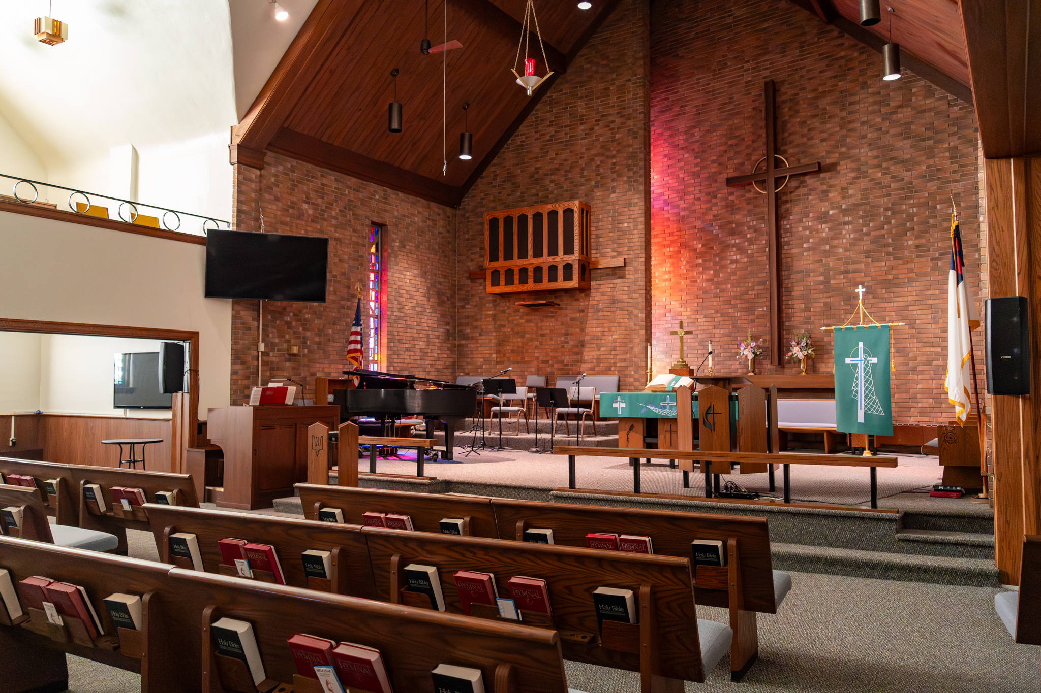 The church sanctuary focused on the stage including a lectern, piano, and organ.